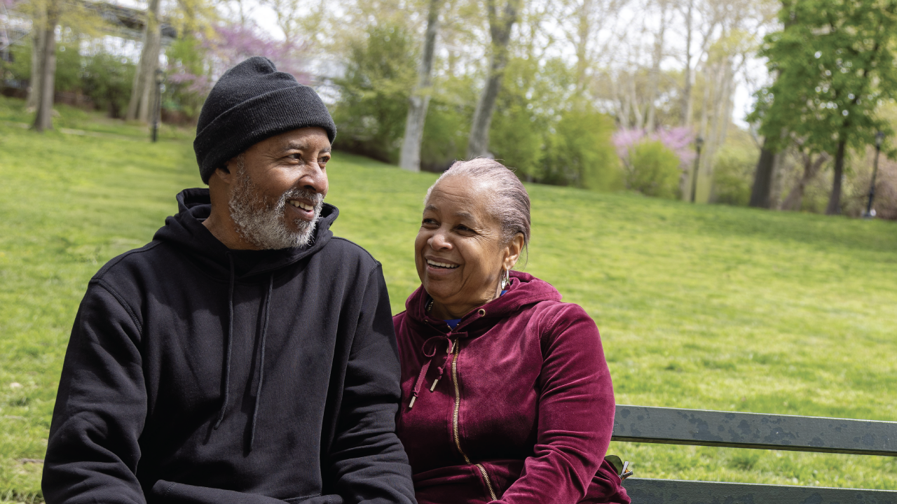 A man and woman sitting on a park bench. 